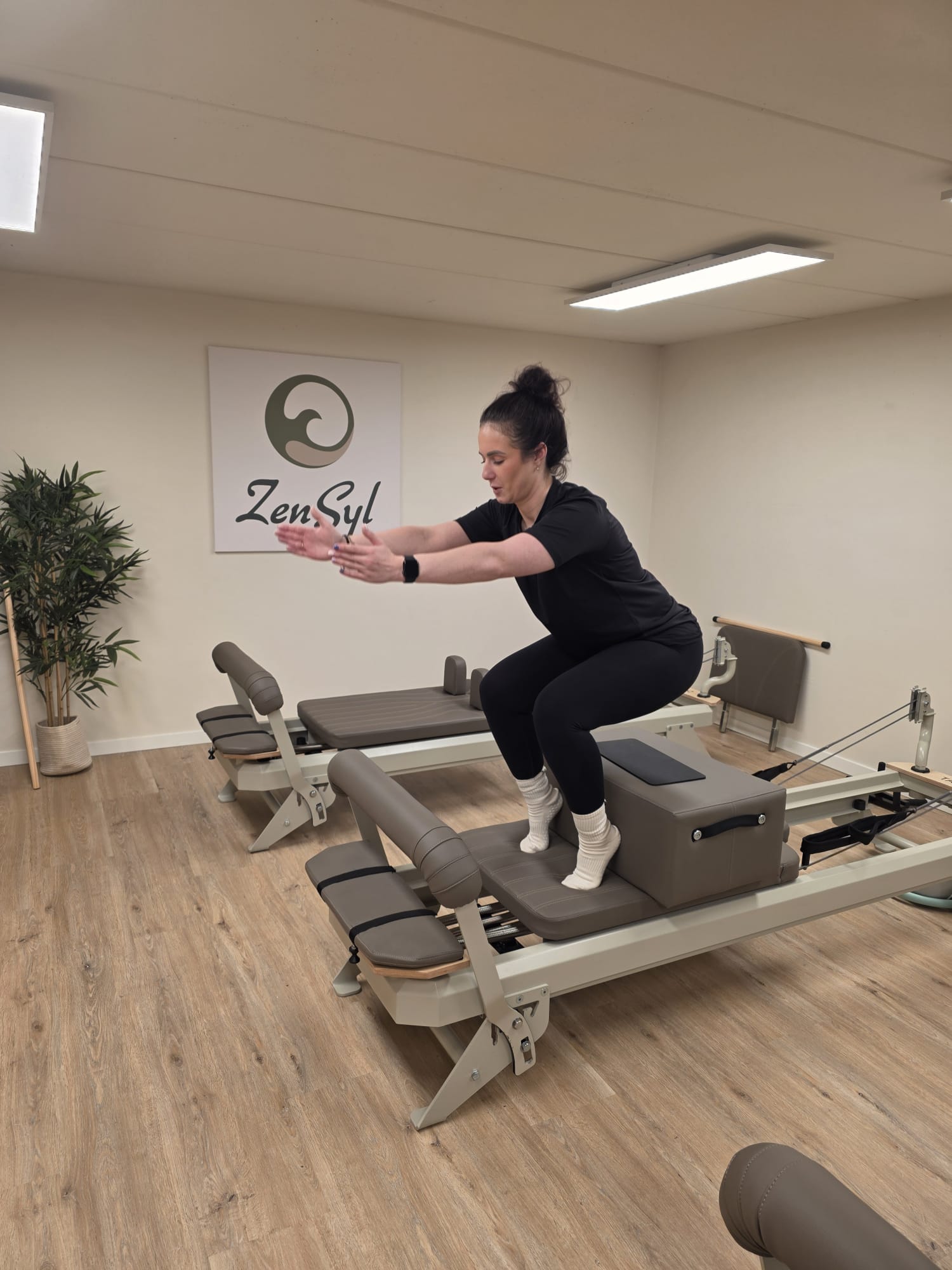 Squat-oefening op de reformerbank voor het ZenSyl logo